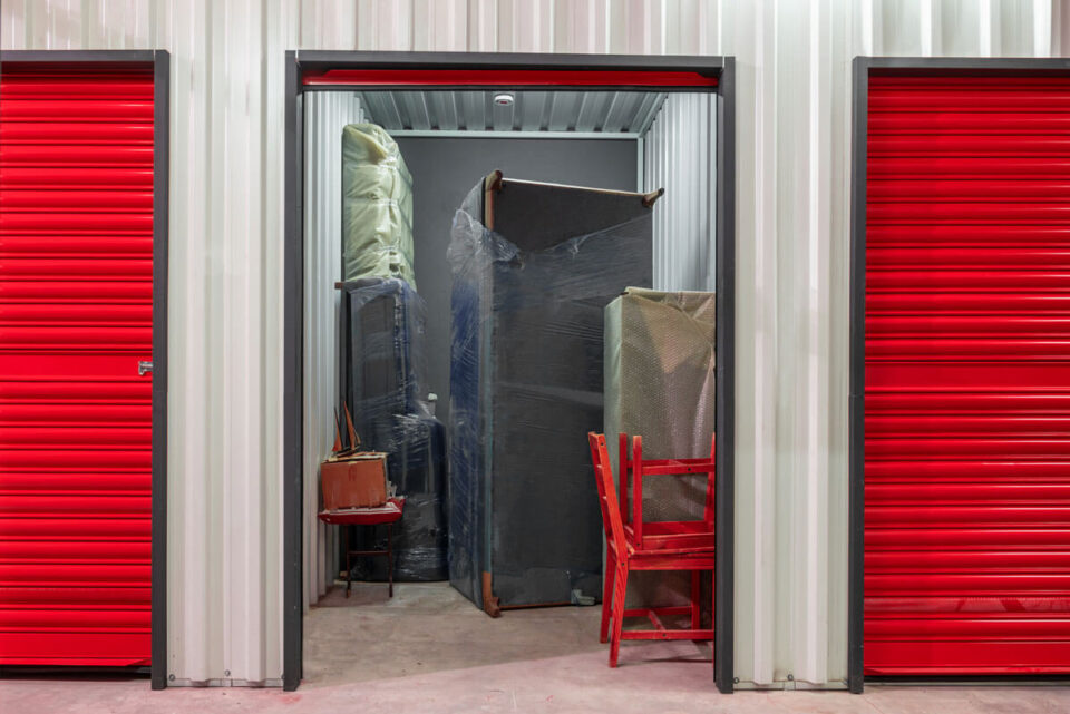 open door to storage unit with various furniture items inside